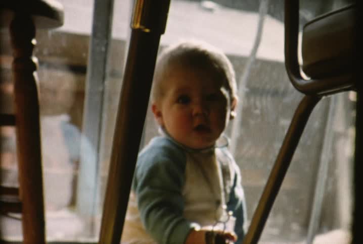 A baby picks up some keys and smiles before crawling away