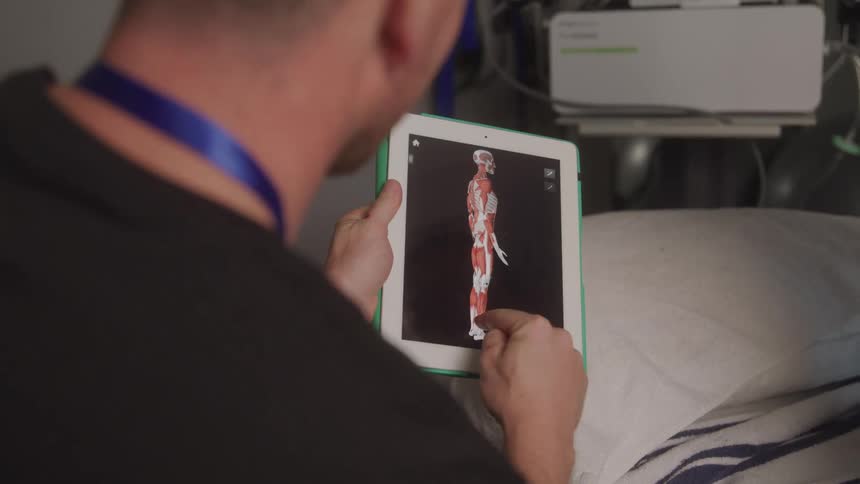 Man holding a tablet and presenting a human body