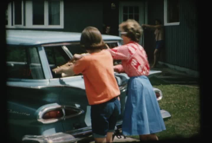Women put a suitcase into a car