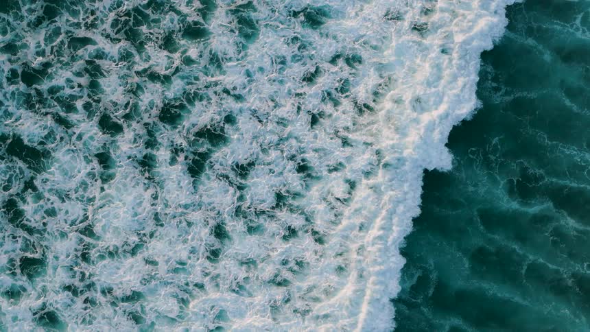 Ariel of white foamy waves rolling across the ocean