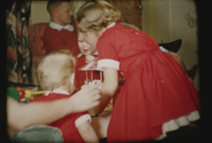 Kids stand around a birthday cake blowing out the candles