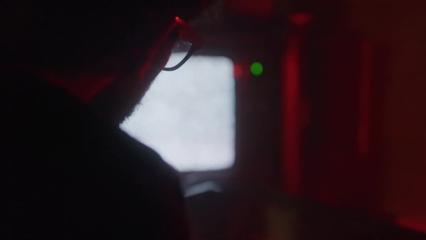 A man looks up at the static filled television screen