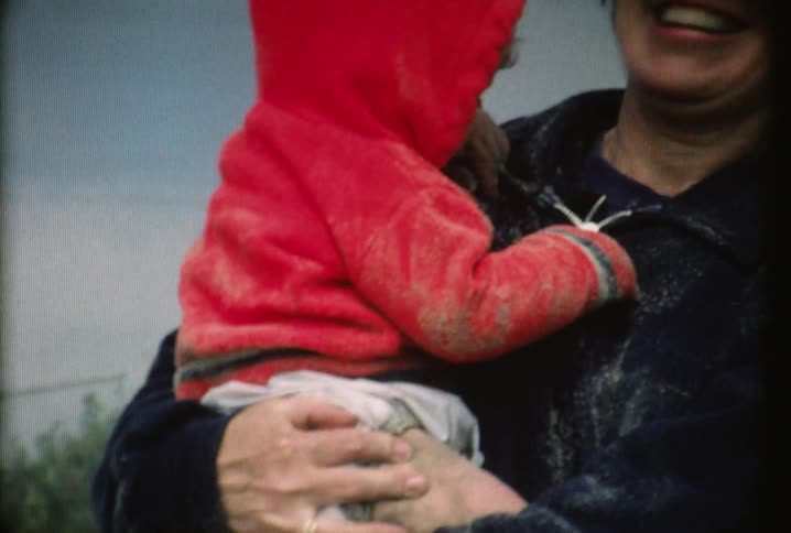 A woman is holding a baby and gives him a kiss