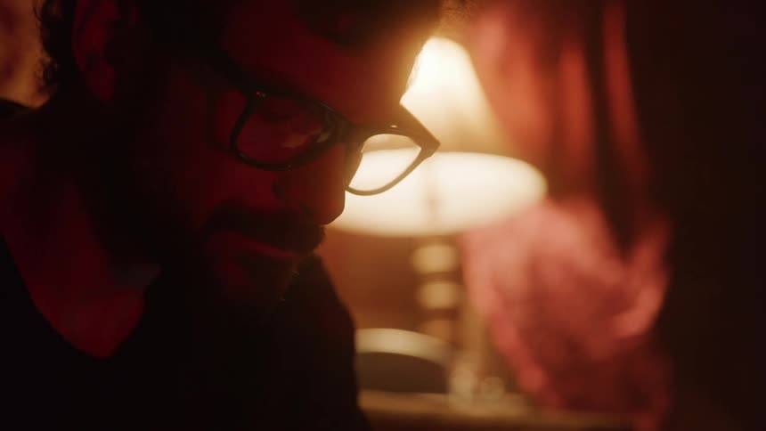 Man with glasses in a bedroom at night