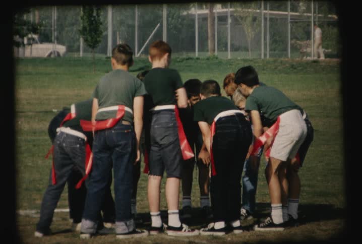 A group of players are huddled on a field
