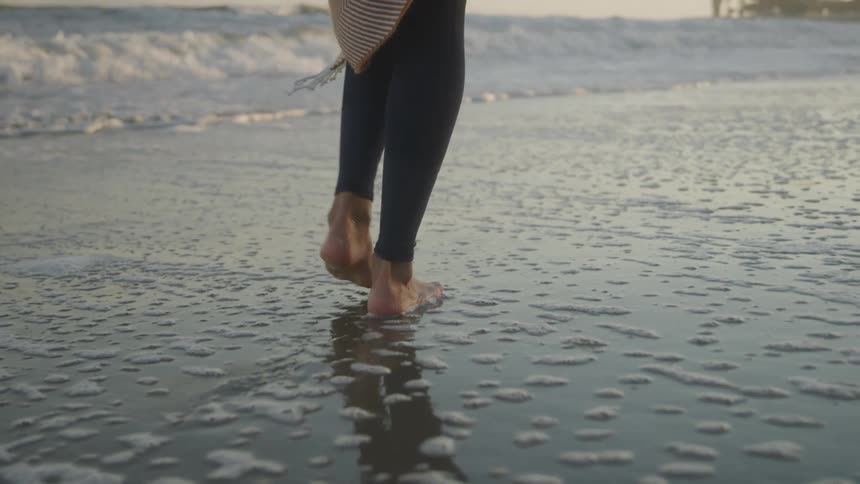 Person walking on wet sand at the beach
