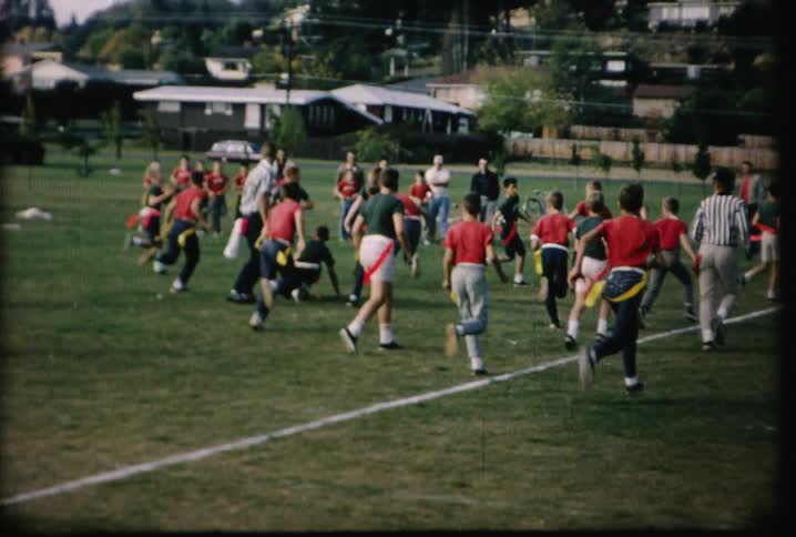 Flag football players run along a field