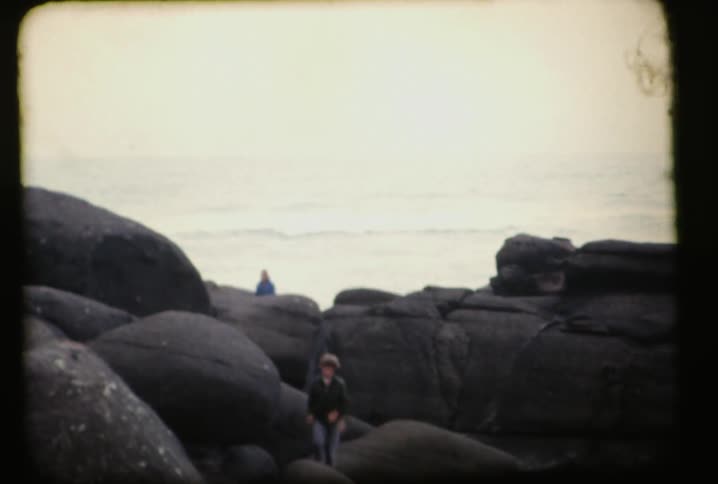 People climb over rocks ahead