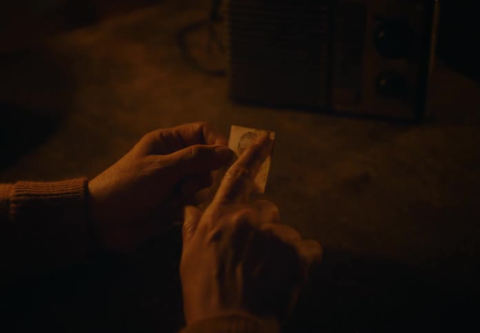 A womans arm holds a photograph of a person