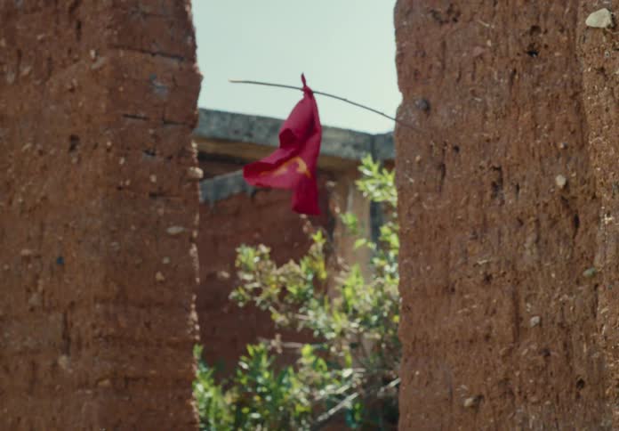 A person walks past a red flag