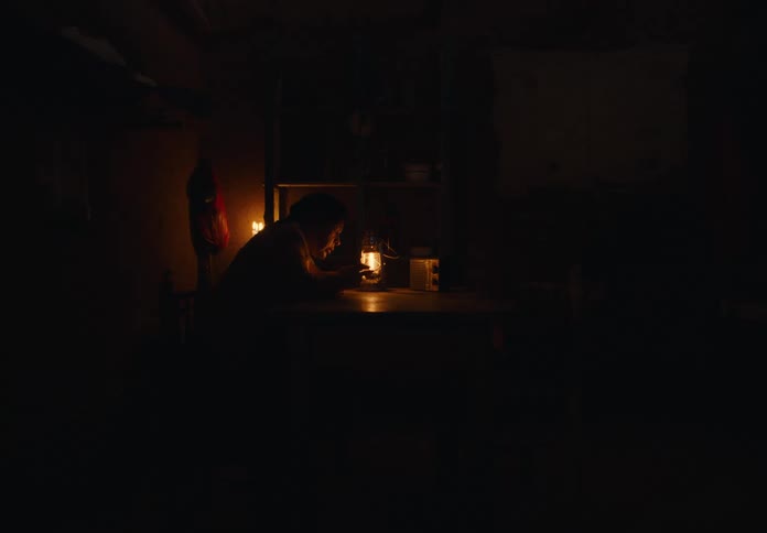 The woman is looking into a lantern