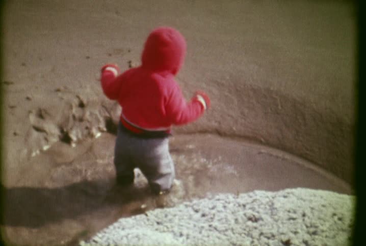 A toddler splashes into water
