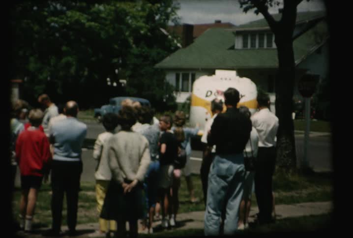 People wave goodbye to a leaving bus