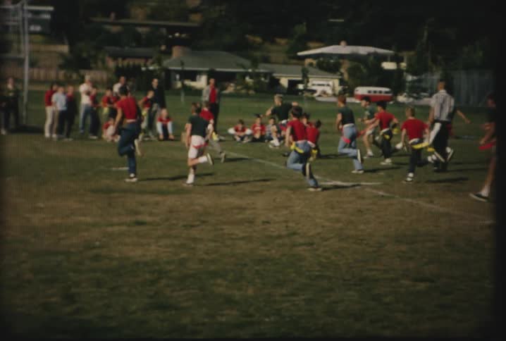 Flag football players charge on a field