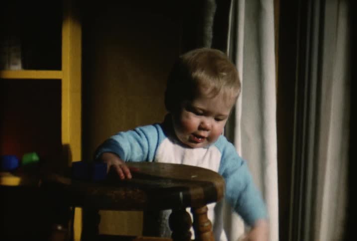 A baby plays with keys on a stool