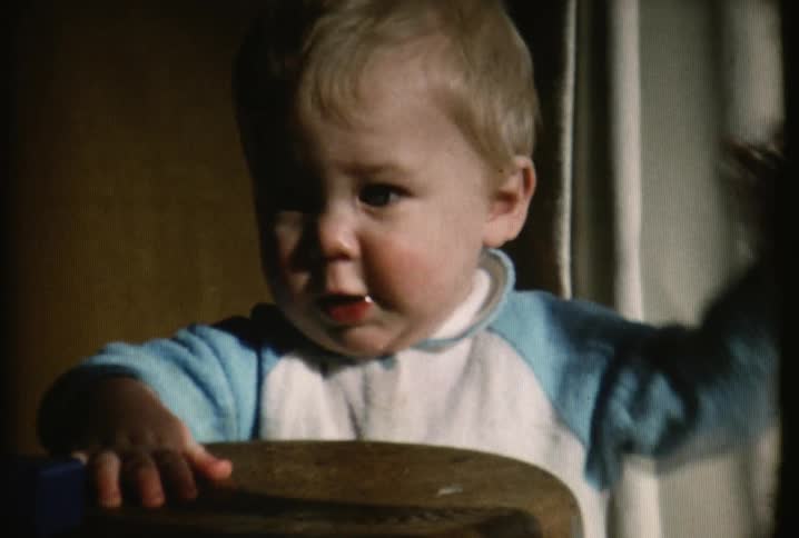 A child takes something from his mouth and looks around