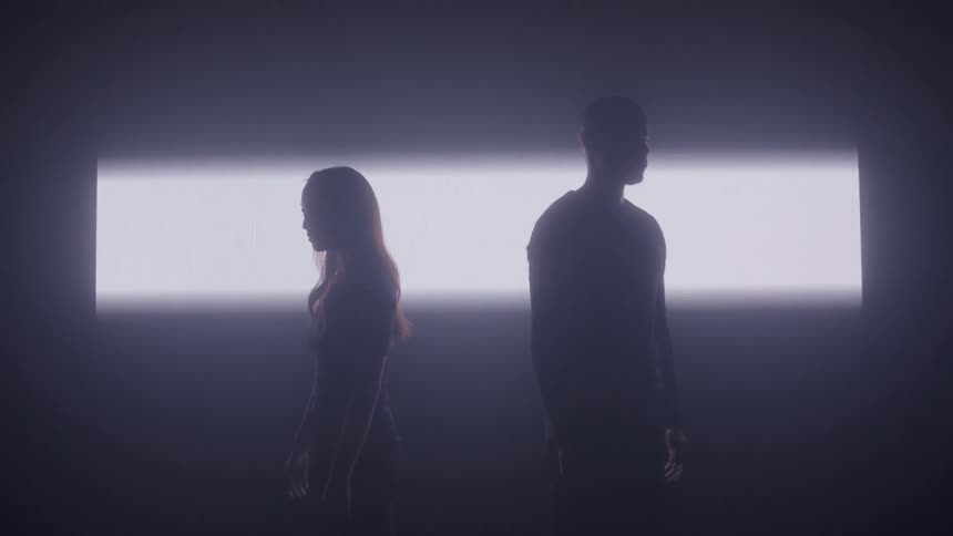 Silhouettes of a woman and a man standing back to back in front of a strip of light