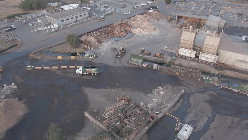 A bulldozer drives around the factory