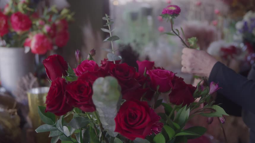 Woman arranging a bouquet of red roses