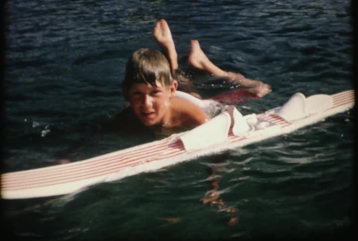 A boy swims near a water ski