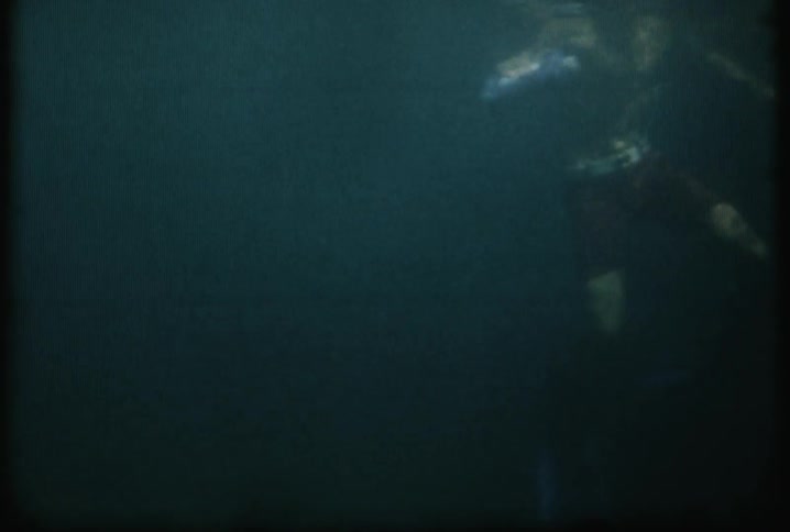 A boy is diving under the dark waters