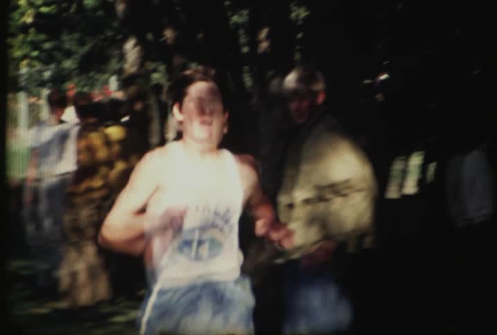 A man running past a group of people in a yard