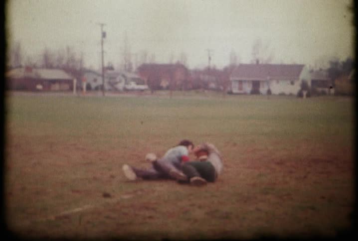 A boy is tackled with a football