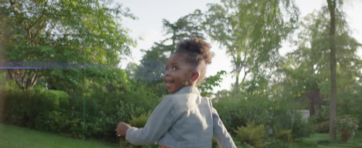 The girl is running through the yard