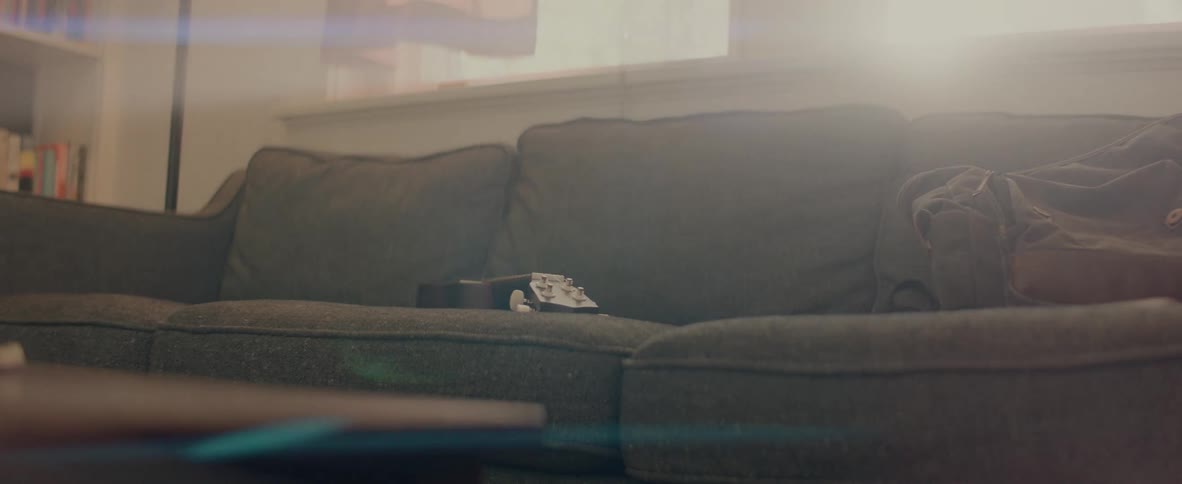 Green sofa with guitar and bag indoors