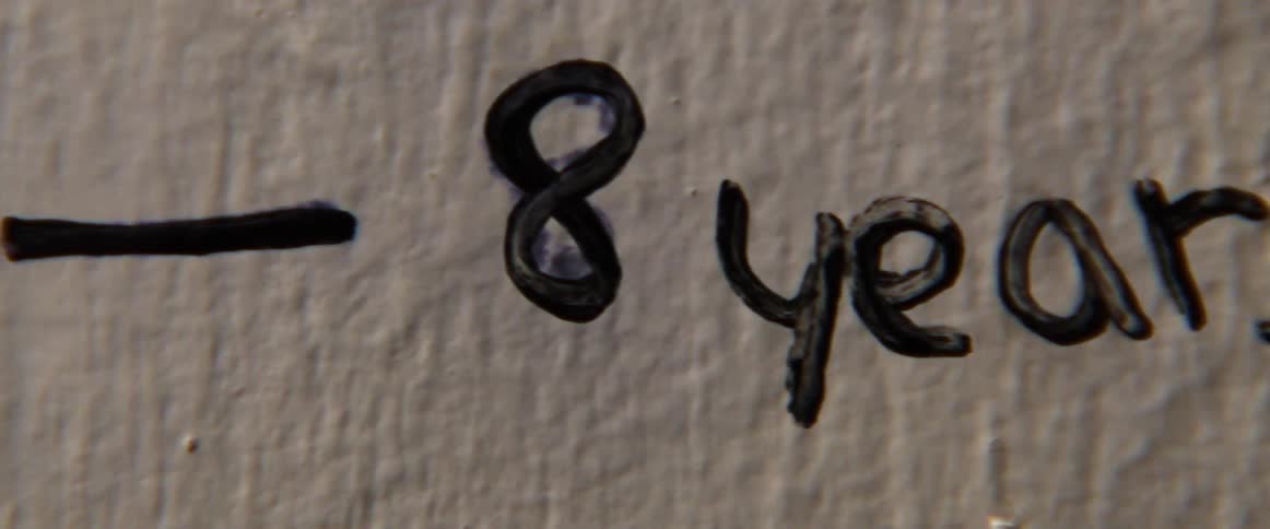 A close up of a height chart written on a wall