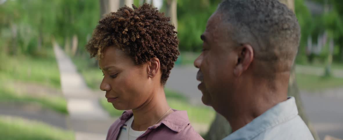 Woman smiling while talking to a man outdoors