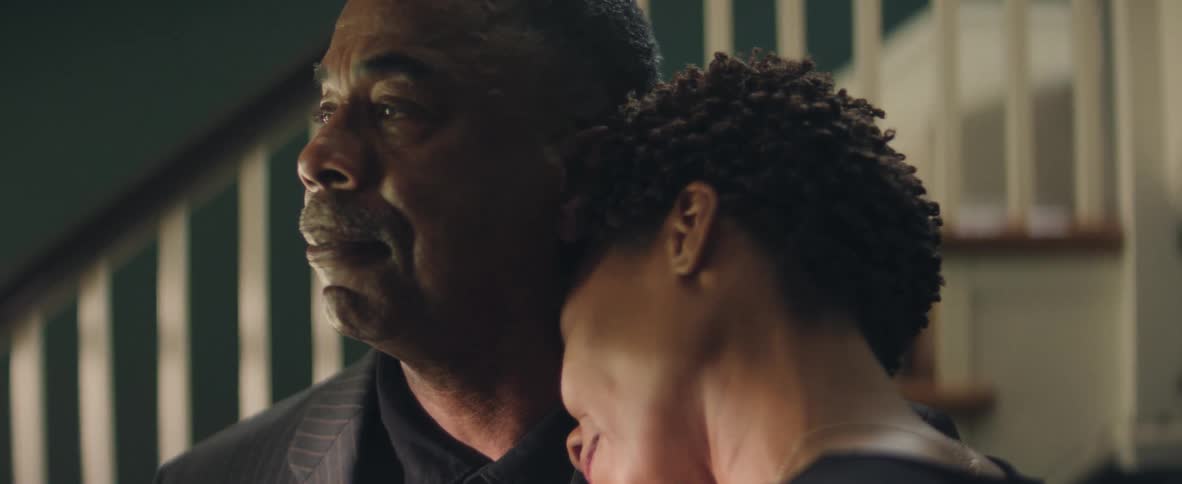 A woman rests her head on a mans shoulder