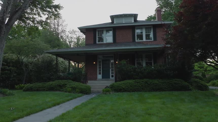 Red brick house stands out among trees and wellkept gardens