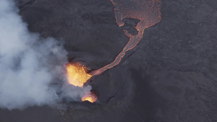 Lava violently erupts from a volcano and flows downhill