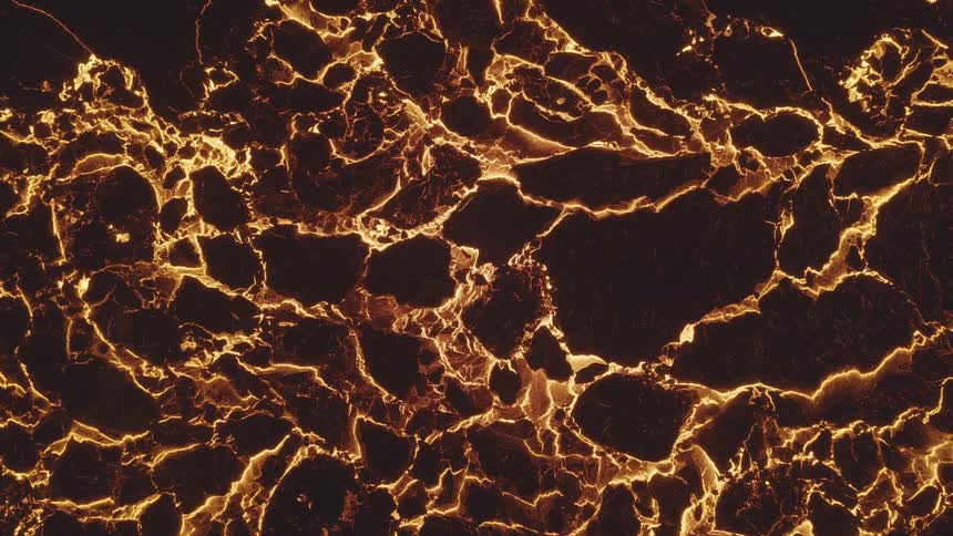 A volcanic eruption on a mountain causes lava to spill all around the mountain at night