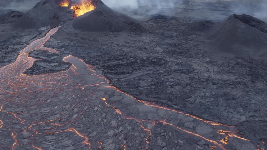 Erupting volcano releases glowing lava and thick smoke across an arid landscape