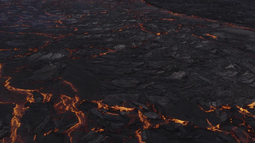 Lava flowing from an erupting volcano is beginning to cool and solidify