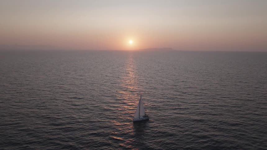 Sailboat sailing alone on the sea during sunset