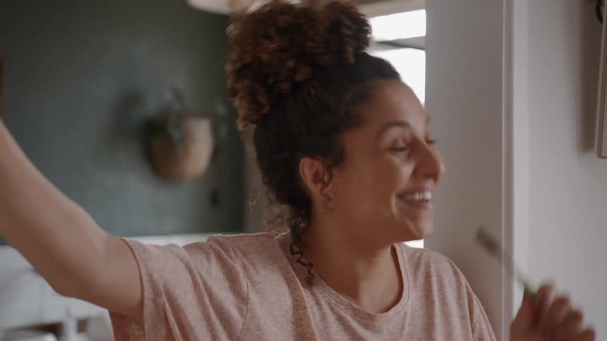 A woman talks while brushing her teeth