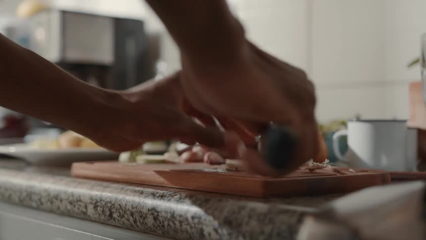 The cook is slicing food in the kitchen