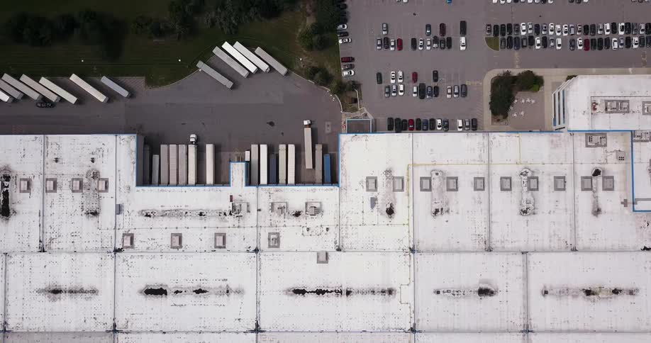 A truck parks between other trucks near a building