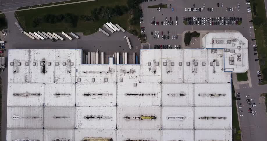 Vehicles sit parked in a shopping center parking lot