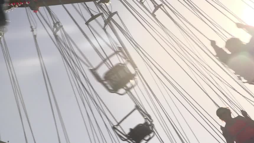 People seated on long swings on a ride