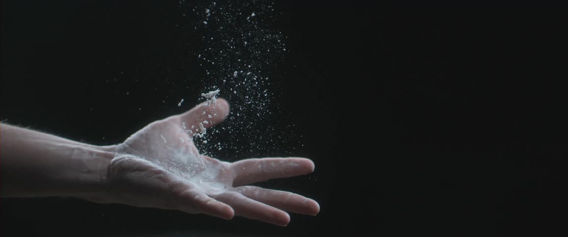 Hand covered with rosin tosses a baseball in the air then catches it