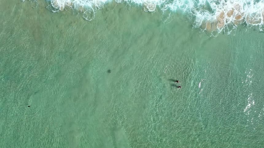 Aerial view of two people enjoying the green sea