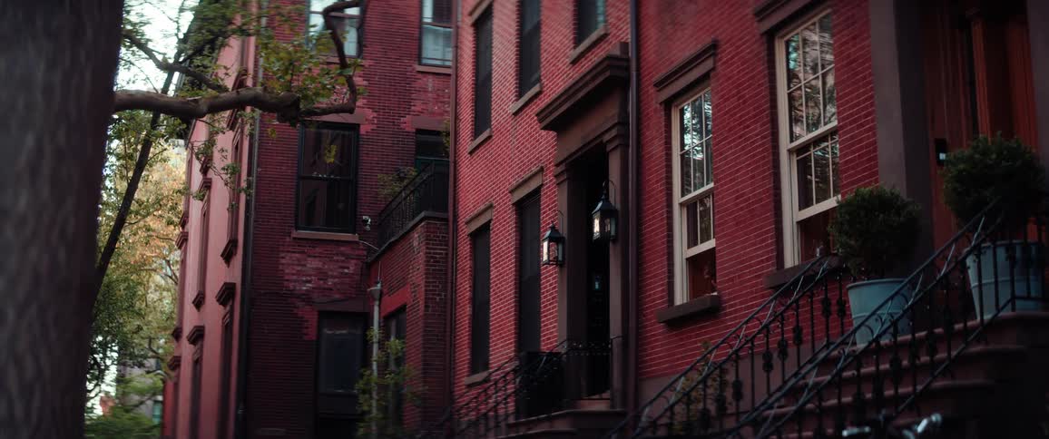 Large red brick buildings with cast iron railings at the edges of the stoops