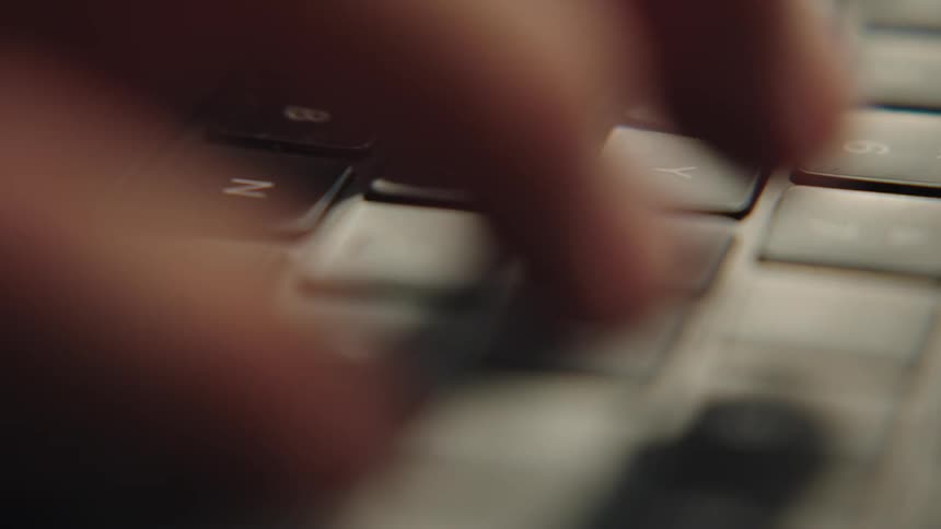 Person types on a laptop computer keyboard