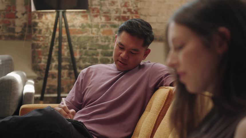 Man and woman sitting in the living room have a brief conversation