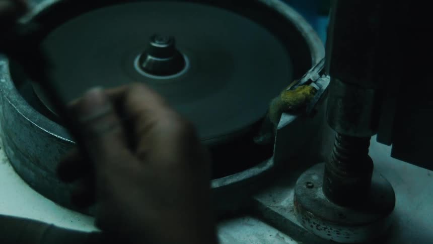 Pair of hands of a person shaping an object on a rotating surface