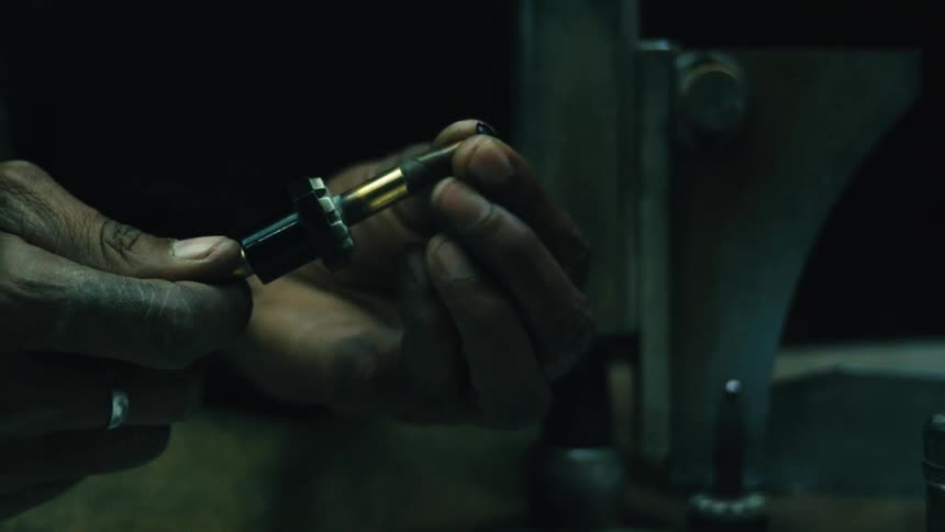 A shot of a person using a torch to heat a piece of metal on a container the person is wearing a ring on their finger